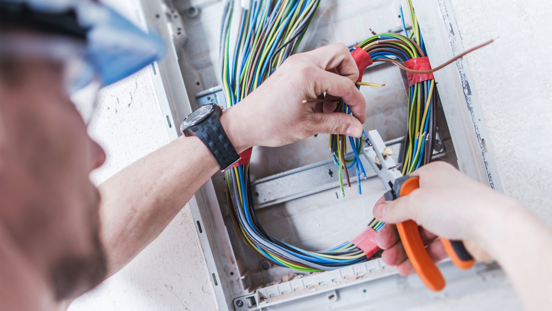 A man is working on a wiring box