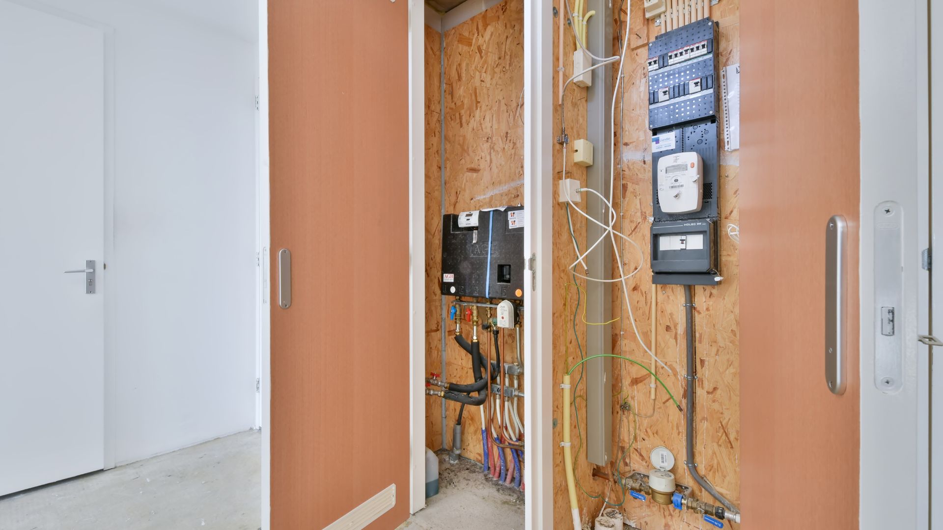 An electrical panel in a room with a wall mounted phone