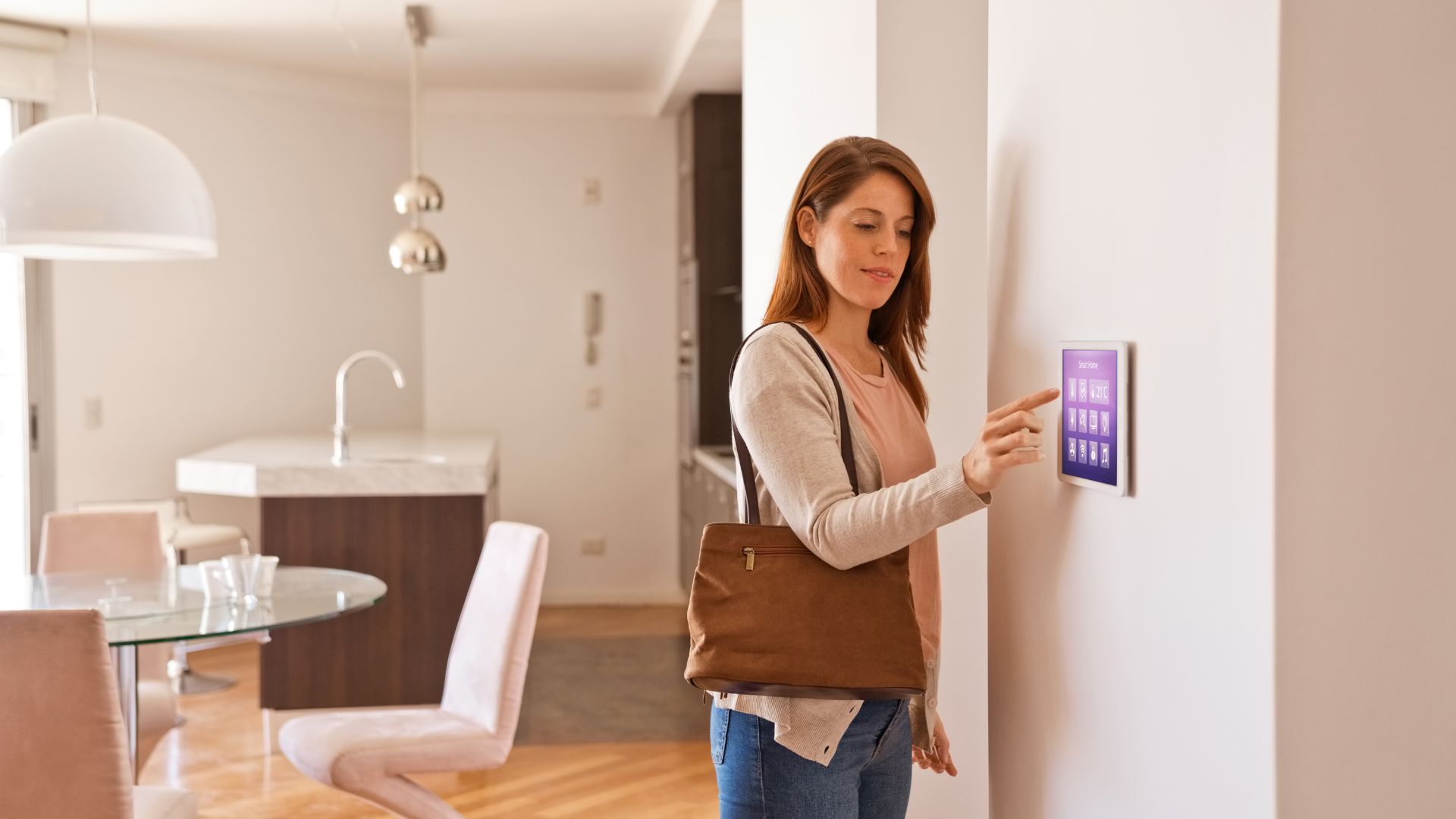 A woman holding a brown bag and pressing a button on a wall